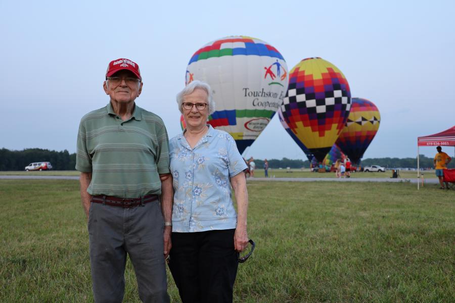 older couple in front of balloons