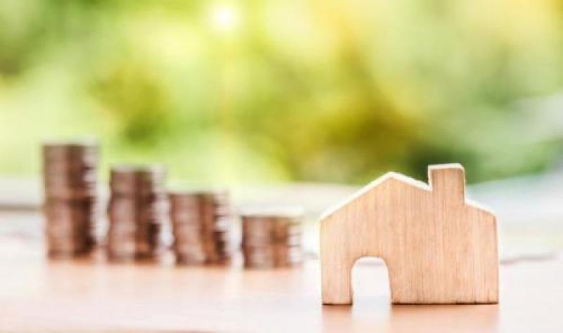 Stacks of coins and wooden house cut-out